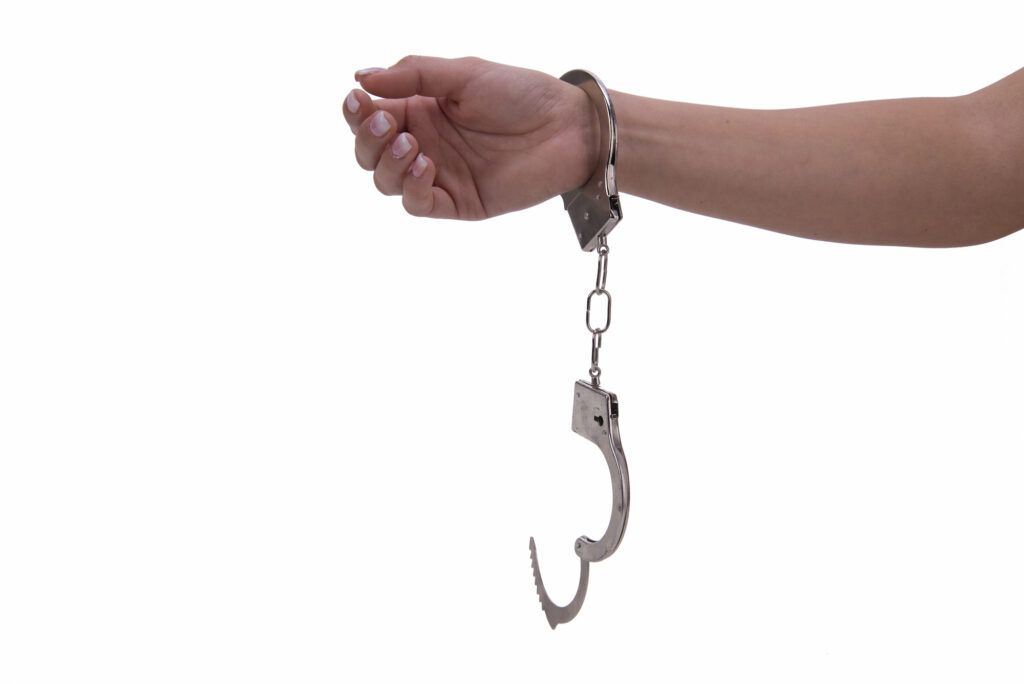 A woman's arm with a handcuff in a white background