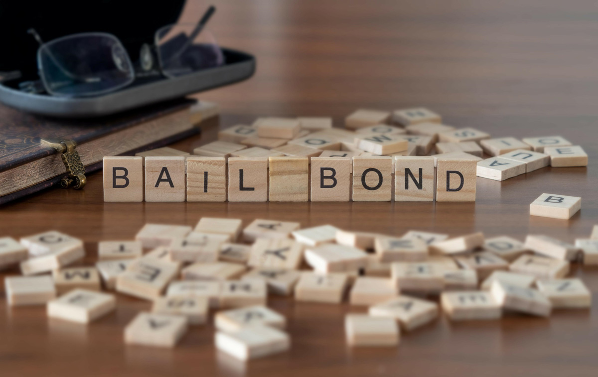 Scrabble tiles spelling out the words “BAIL BOND” on a desk in El Paso.