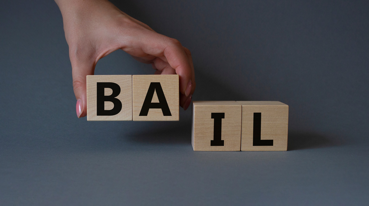 A person holding wooden blocks that read “BAIL” in El Paso.