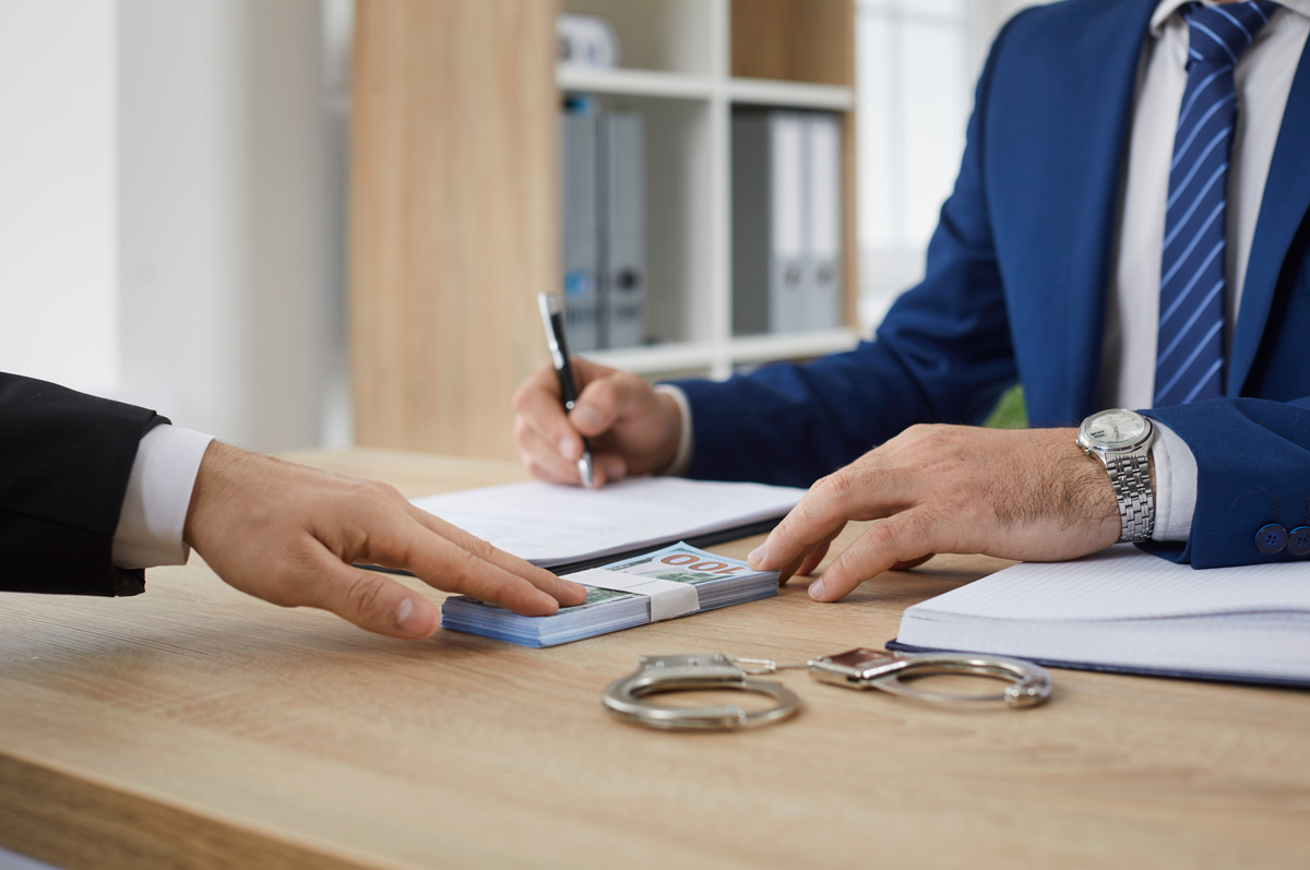 Two people at a desk exchanging money for a bail bond in El Paso.